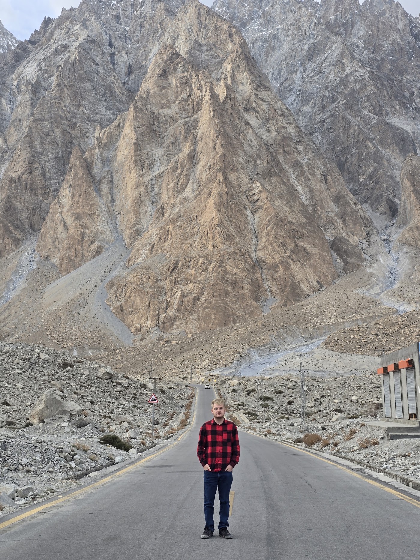 Standing on a road beneath steep mountains